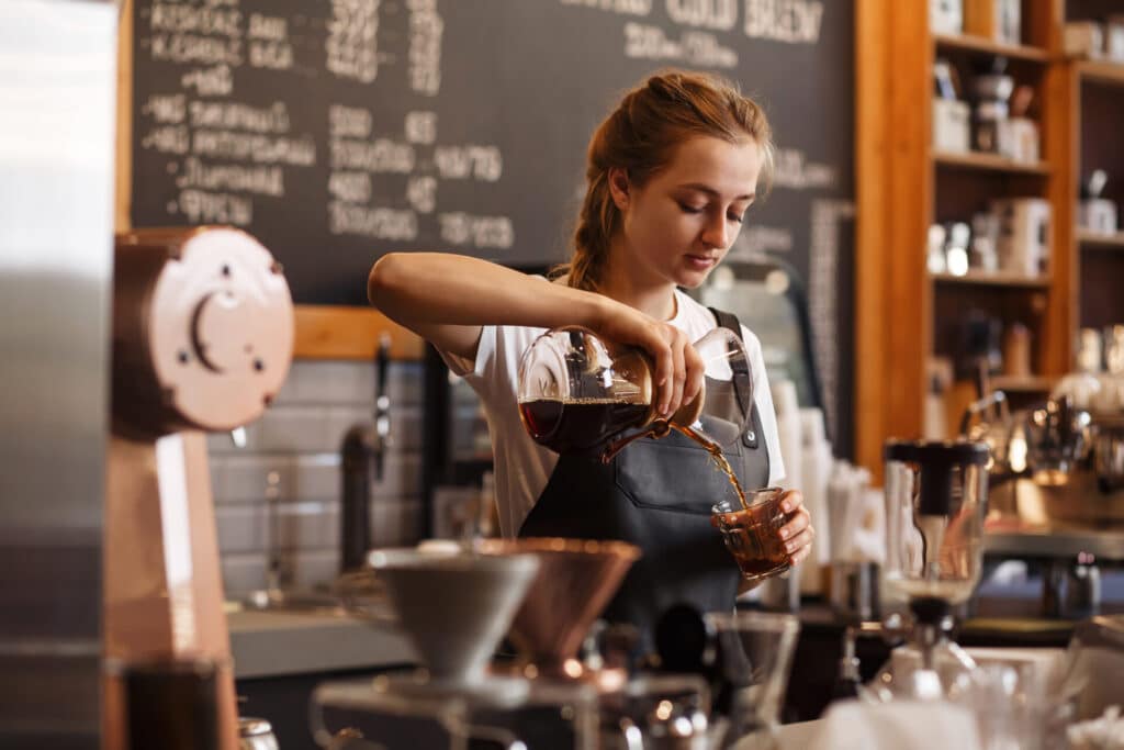 employee making coffee at small business